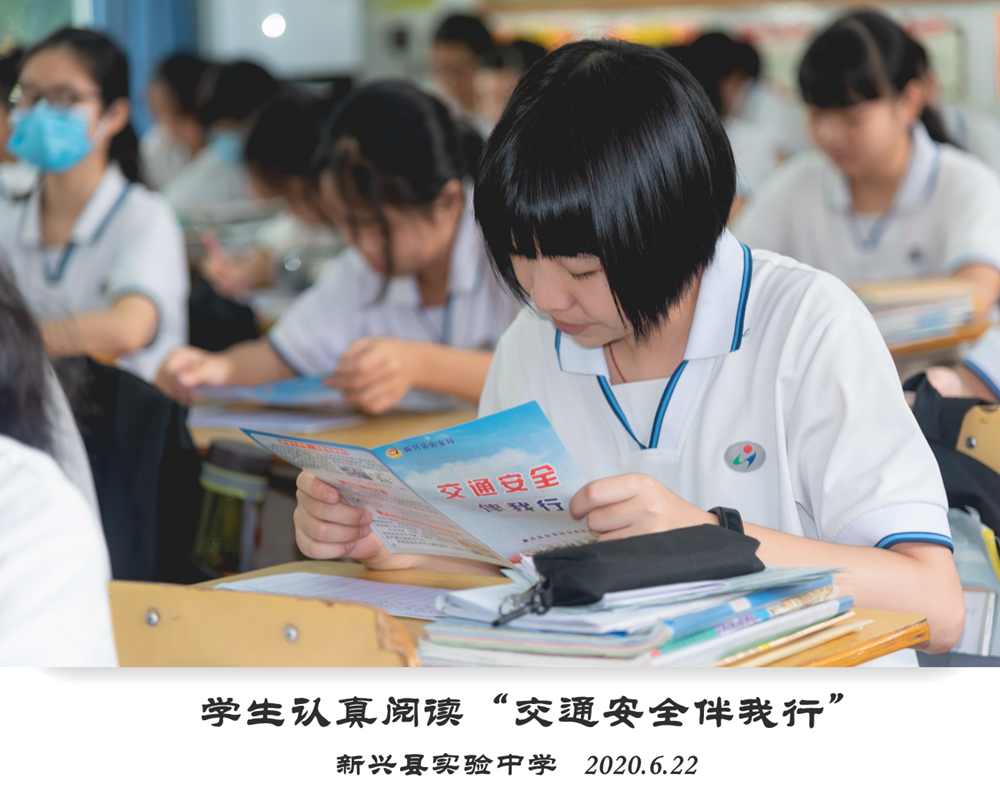 新兴县实验中学学生在交通安全主题班会上，阅读交通安全知识宣传单张。_副本.png